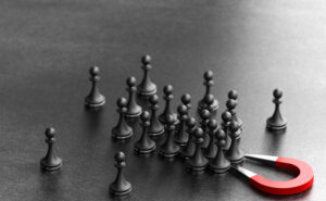 Magnet attracting chess pieces symbolizing attracting and retaining talent
